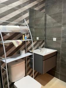 a bathroom with a sink and a toilet and a shelf at Studio meublé au quartier du parc in Mohammedia