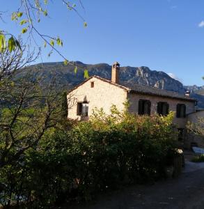 une maison ancienne avec une montagne en arrière-plan dans l'établissement Cal Martí, à Abella de la Conca