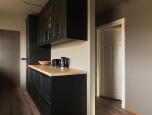 a kitchen with black cabinets and a counter top at Klöpp Lodge - Snæfellsnes Peninsula in Stykkishólmur