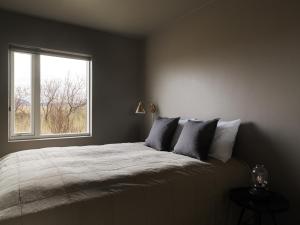 1 dormitorio con 1 cama grande y ventana en Klöpp Lodge - Snæfellsnes Peninsula, en Stykkishólmur