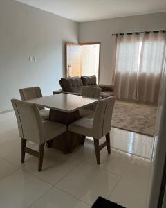 a dining table and chairs in a living room at Apto térreo Mãe Aparecida 8 pessoas 3km do santuário com WiFi ,ar condicionado nos quartos in Aparecida