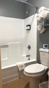La salle de bains est pourvue de toilettes blanches et d'une baignoire. dans l'établissement Fort Davis Inn & RV Park, à Fort Davis