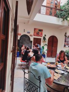 un grupo de personas sentadas en una mesa en un restaurante en Riad white flowers en Marrakech