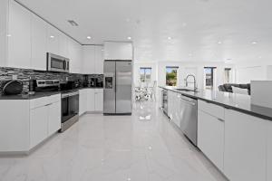 a kitchen with white appliances and a white floor at Private Spacious House #BBQ - Hallandale Beach, Florida in Hallandale Beach