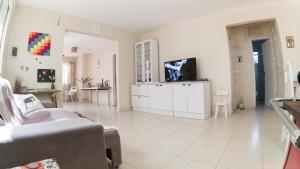 uma sala de estar com um sofá e uma televisão em Casa Familiar Estaleiro no Balneário Camboriú