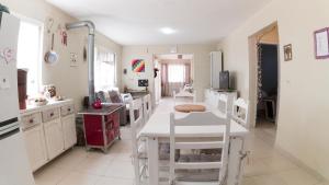 a kitchen with a white table and white chairs at Casa Familiar Estaleiro in Balneário Camboriú