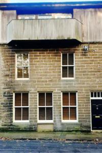 a brick building with windows and a wooden roof at Ensuite Rooms in Wick