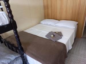 een slaapkamer met 2 bedden en een handdoek op het bed bij Suíte Barros in Navegantes