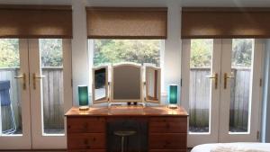 a mirror on a dresser in a room with windows at Ensuite Rooms in Wick +2 photos