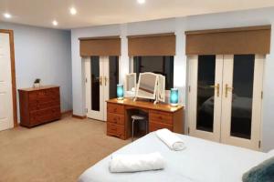 a bedroom with a bed and a desk with a mirror at Ensuite Rooms in Wick