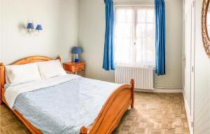 a bedroom with a bed with blue curtains and a window at Awesome Home In Trévou Treguignec in Trélévern