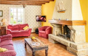 ein Wohnzimmer mit einem Kamin und roten Möbeln in der Unterkunft Awesome Home In Trvou Treguignec With 4 Bedrooms And Wifi in Trélévern