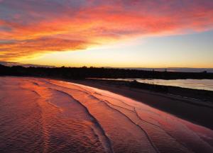 um pôr-do-sol numa praia com o oceano em Atlantic Beach Hotel Newport em Middletown