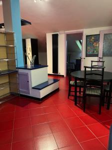 トリノにあるHOUSE Lingottoの赤い床の客室で、テーブルと椅子が備わります。