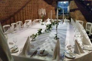 a long table with a white table cloth and white chairs at The Old Mill, 7 storey,, dog friendly outdoor pool & bbq in Stoke Ferry