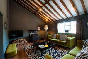 a living room with a couch and a fireplace at The Old Mill, 7 storey,, dog friendly outdoor pool & bbq in Stoke Ferry