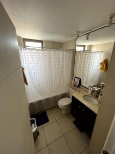 a bathroom with a toilet and a sink and mirror at apartamento con vista al mar y piscina. in Iquique