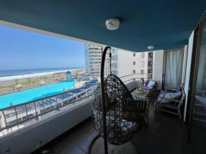 a room with a balcony with a view of the ocean at apartamento con vista al mar y piscina. in Iquique