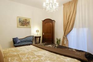 ein Schlafzimmer mit einem Bett, einem Stuhl und einem Kronleuchter in der Unterkunft B&B Old Town San Marino in San Marino