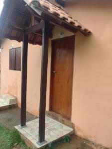 uma porta de madeira ao lado de uma casa em SITIO CAMINHO DAS PEDRAS - Suítes e Chalés em São Thomé das Letras