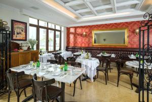 a restaurant with tables and chairs and a mirror at Grand Hotel Tepatitlán in Tepatitlán de Morelos