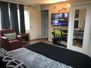 Dormitorio con cama, escritorio y TV en 2 bedroom house or Private Studio in quiet neighborhood near SF, SFSU and SFO, en Daly City