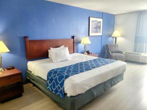 a bedroom with a large bed and a blue wall at Baymont by Wyndham Hannibal in Hannibal +32 photos
