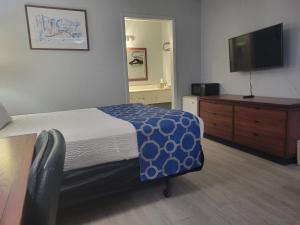 a bedroom with a bed and a flat screen tv at Baymont by Wyndham Hannibal in Hannibal