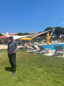 a man standing in the grass next to a swimming pool at House of Rising Sun in Quarteira