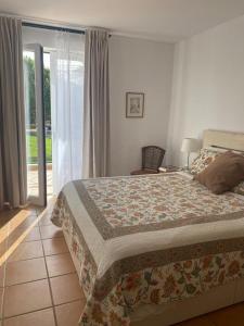 een slaapkamer met een bed en een glazen schuifdeur bij House of Rising Sun in Quarteira