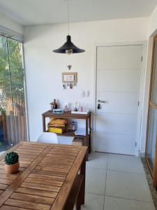 a dining room with a wooden table and a desk at Riverside imbassai bloco B003 in Mata de Sao Joao