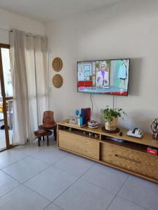 a living room with a flat screen tv on a wall at Riverside imbassai bloco B003 in Mata de Sao Joao