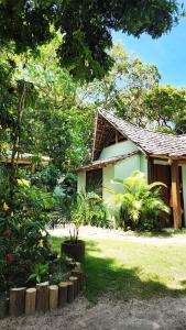 una casa con algunas plantas delante de ella en Pousada Mangue Sereno, en Caraíva