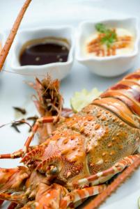 a plate of food with a lobster and some sauces at The Palms Zanzibar in Bwejuu