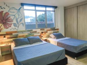 a bedroom with two beds and a flower mural at Neim Platinum Hotel in Medellín