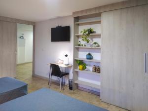 a room with a desk and a tv on a wall at Neim Platinum Hotel in Medellín
