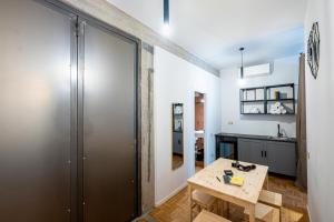 Habitación con mesa de madera y cocina. en MyTinyHome Festina Lente, en Roma