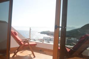 two chairs on a balcony with a view of the ocean at The Occidental House in Tamaduste