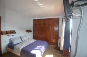 1 dormitorio con 1 cama y TV en The Occidental House, en Tamaduste