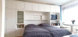 um quarto com armários brancos e uma cama em Haus Oose em Westerland