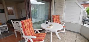 uma mesa branca e cadeiras num alpendre em Haus Oose em Westerland
