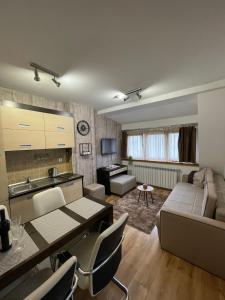 un soggiorno con divano e tavolo di NEW!!! 4 stars apartment!!! a Kopaonik