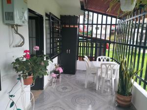 une terrasse couverte avec une table, des chaises et des plantes dans l'établissement apartamento family, à Santa Rosa de Cabal