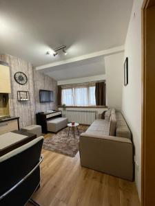 un soggiorno con divano e tavolo di NEW!!! 4 stars apartment!!! a Kopaonik