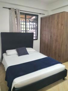ein Schlafzimmer mit einem großen Bett mit einer blauen Decke in der Unterkunft apartamento family in Santa Rosa de Cabal