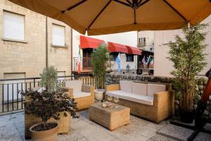 a patio with two couches and an umbrella at B&B Old Town San Marino in San Marino