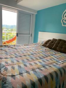 Un dormitorio con una cama grande con una ventana grande. en Apartamento Veleiros da Ilha - Praia do Tombo, en Guarujá 48 fotos más