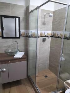 y baño con ducha acristalada y lavamanos. en apartamento family, en Santa Rosa de Cabal