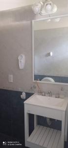 y baño con lavabo blanco y espejo. en Chalet de 2 dorm- 1baño - Piscina en Valeria del Mar