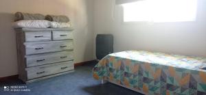 a bedroom with a dresser and a bed and a window at Chalet de 2 dorm- 1baño - Piscina in Valeria del Mar +7 photos